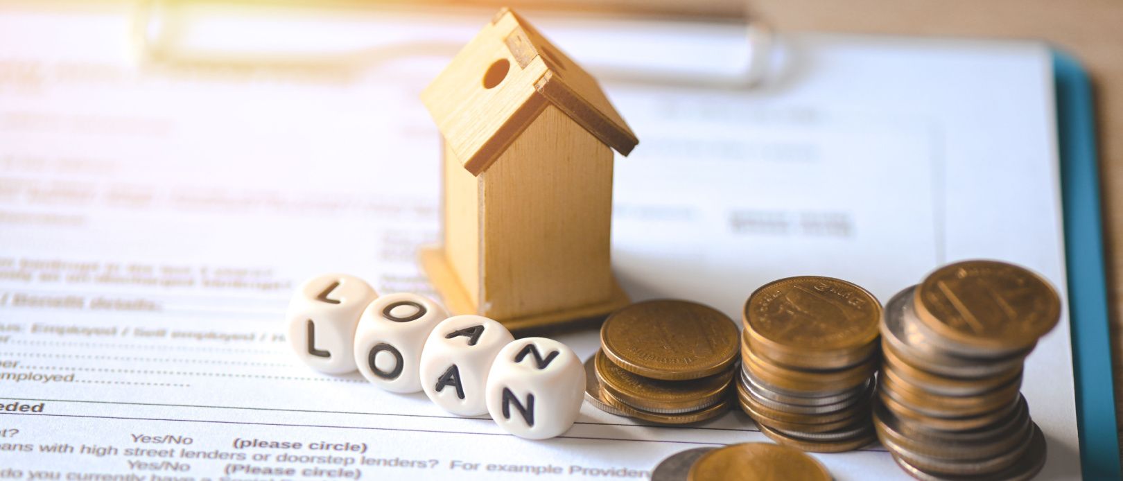 Home loan concept, Loan application form paper with money coin and loan house model on table